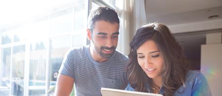 Two people looking at tablet and smiling