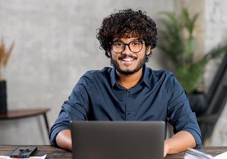 Young Man Smiling While On Laptop