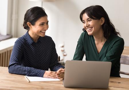 Two Female Employees Smiling With Laptop